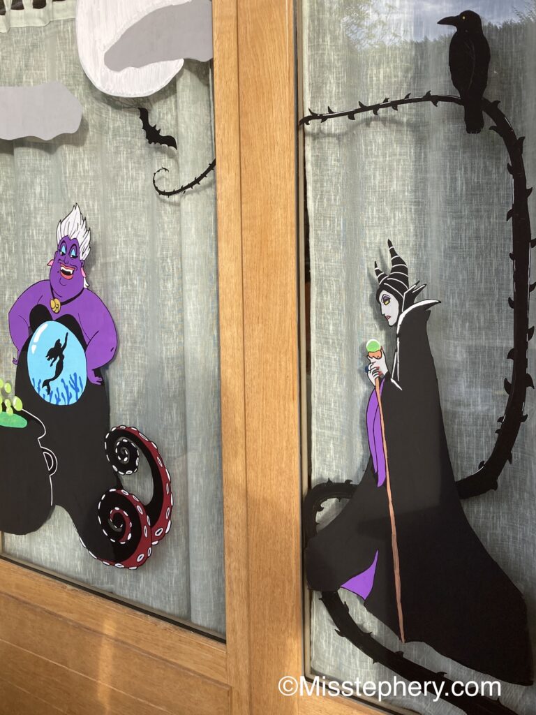 Décoration Halloween au feutre Posca sur vitre avec Maléfique et son corbeau ainsi qu'Ursula