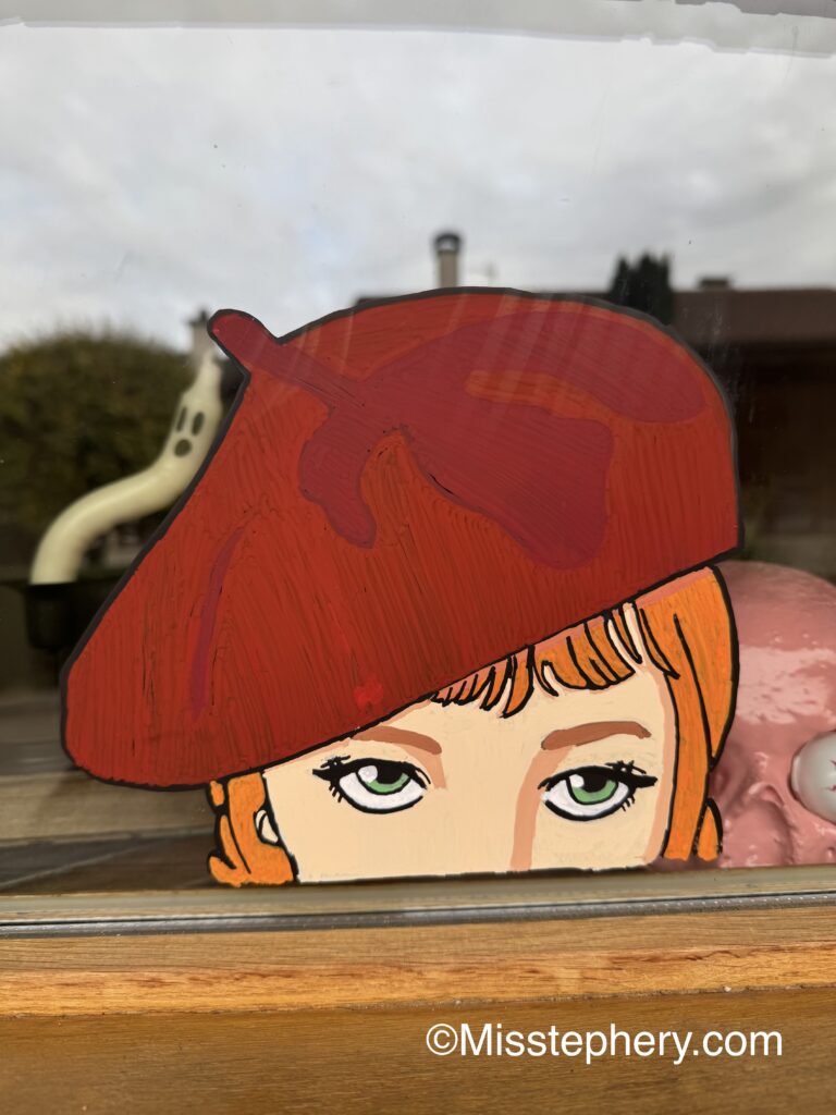 Décoration sur vitre au Posca représentant le visage du personnage d'Agnès de la série Mercredi