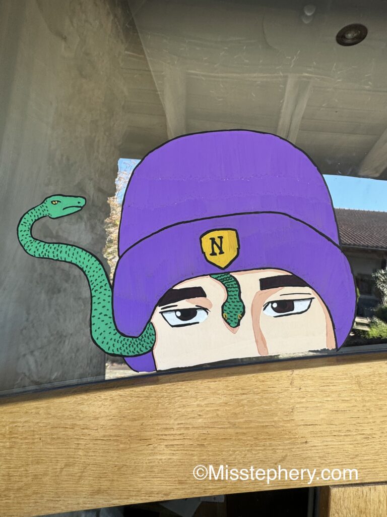 Dessin sur vitre au feutre Posca du gorgone Ajax Petropolus avec son bonnet et ses serpents.