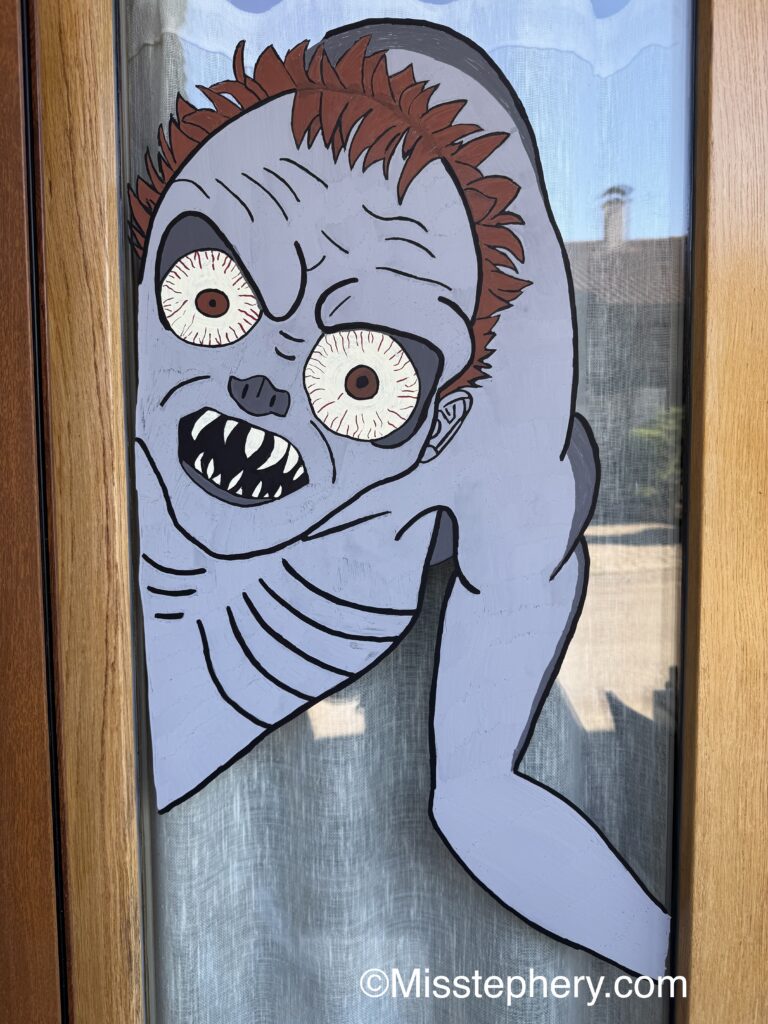 Dessin sur fenêtre du monstre Hyde de la série Mercredi réalisé au feutre Posca pour Halloween