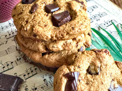 Cookies au miso et pépites de chocolat noir sans gluten et sans lactose, présentés sur une partition de musique à côté d'une théière en fonte.