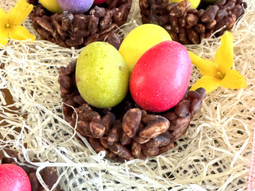 Nids de Pâques façon rose des sables au riz soufflé & chocolat (sans gluten ni lactose) avec des oeufs de dinosaure de la marque PECOU à l'intérieur. posé sur du Raphia