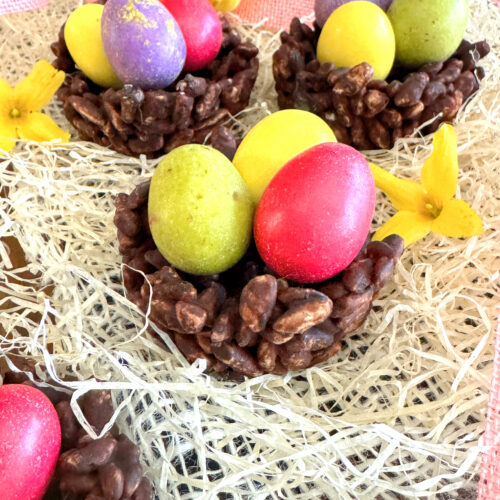 Nids de Pâques façon rose des sables au riz soufflé & chocolat (sans gluten ni lactose) avec des oeufs de dinosaure de la marque PECOU à l'intérieur. posé sur du Raphia